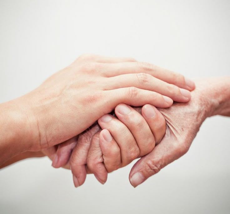 Tender hands of caregiver and senior